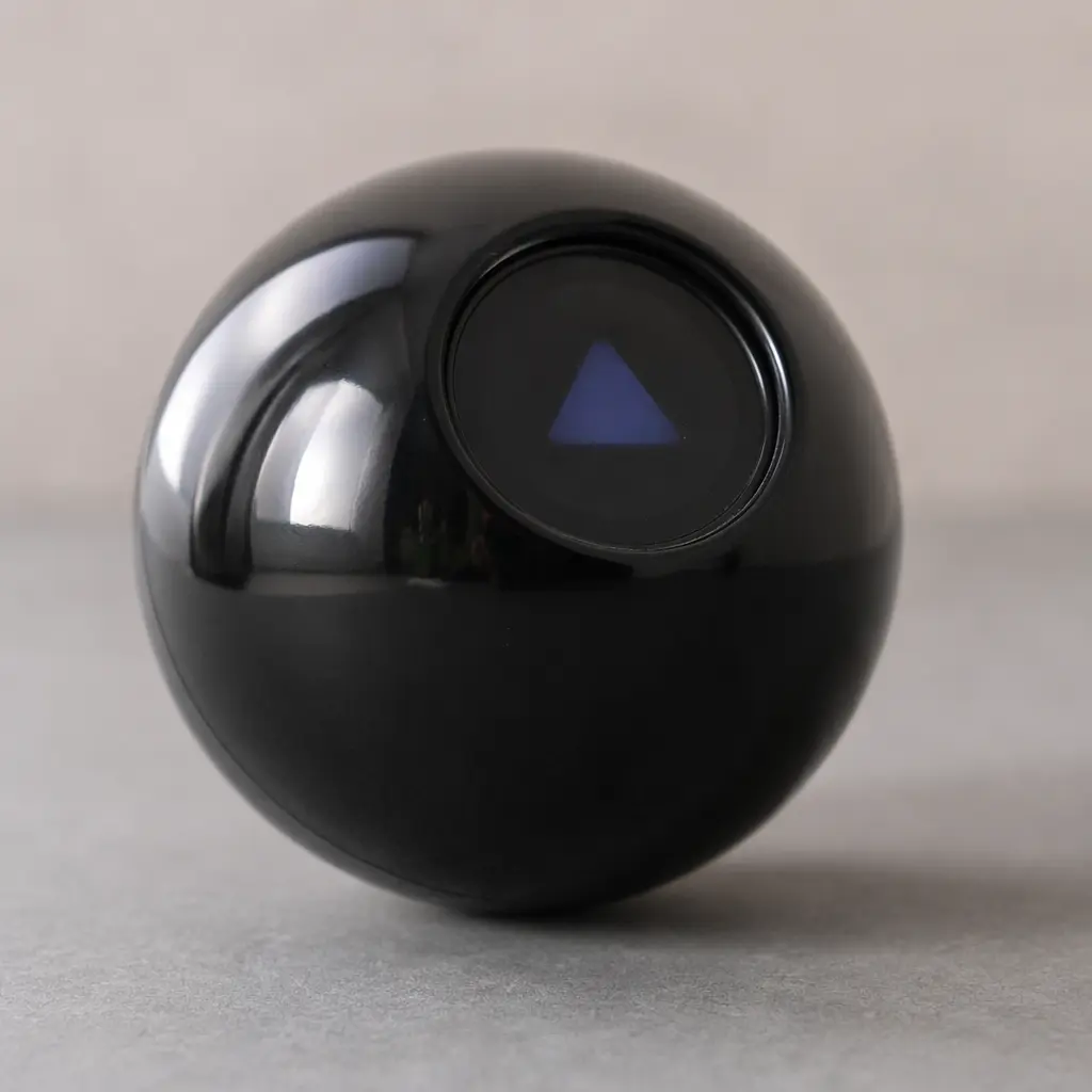 A black spherical fortune toy with a small answer window on a table