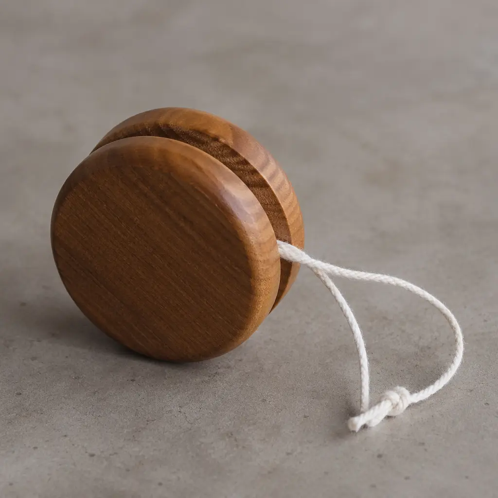 A classic wooden yo-yo with string on a tabletop