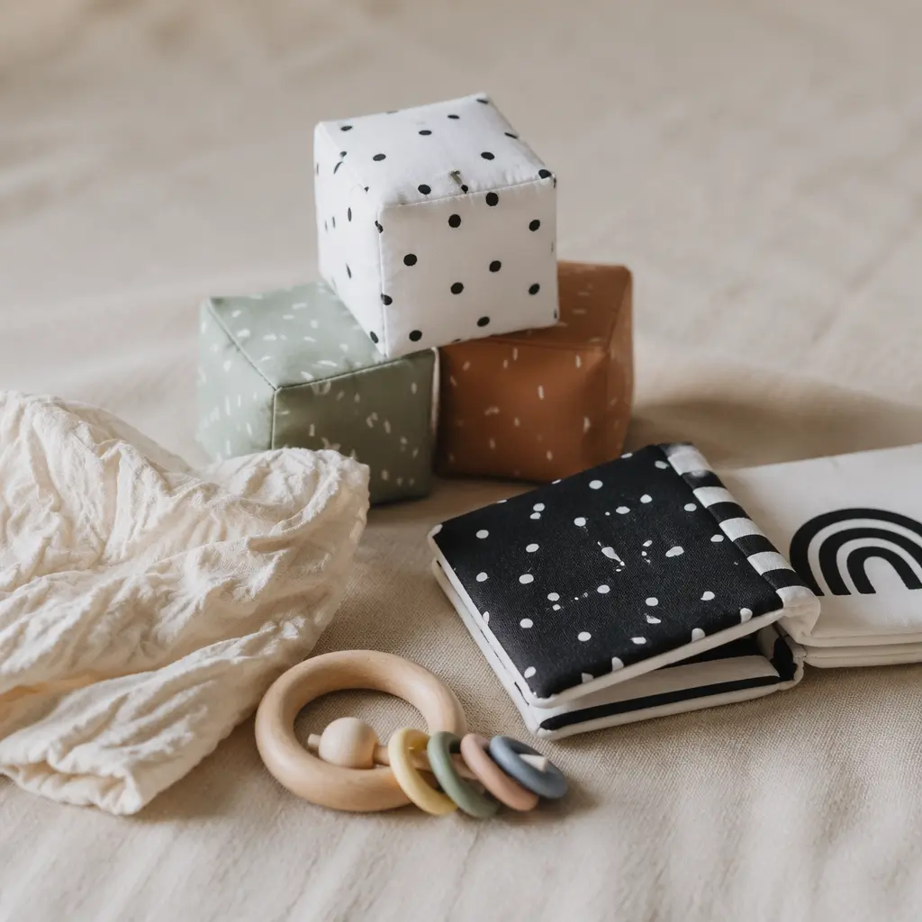 Simple battery-free sensory toys for newborns arranged in soft natural light.