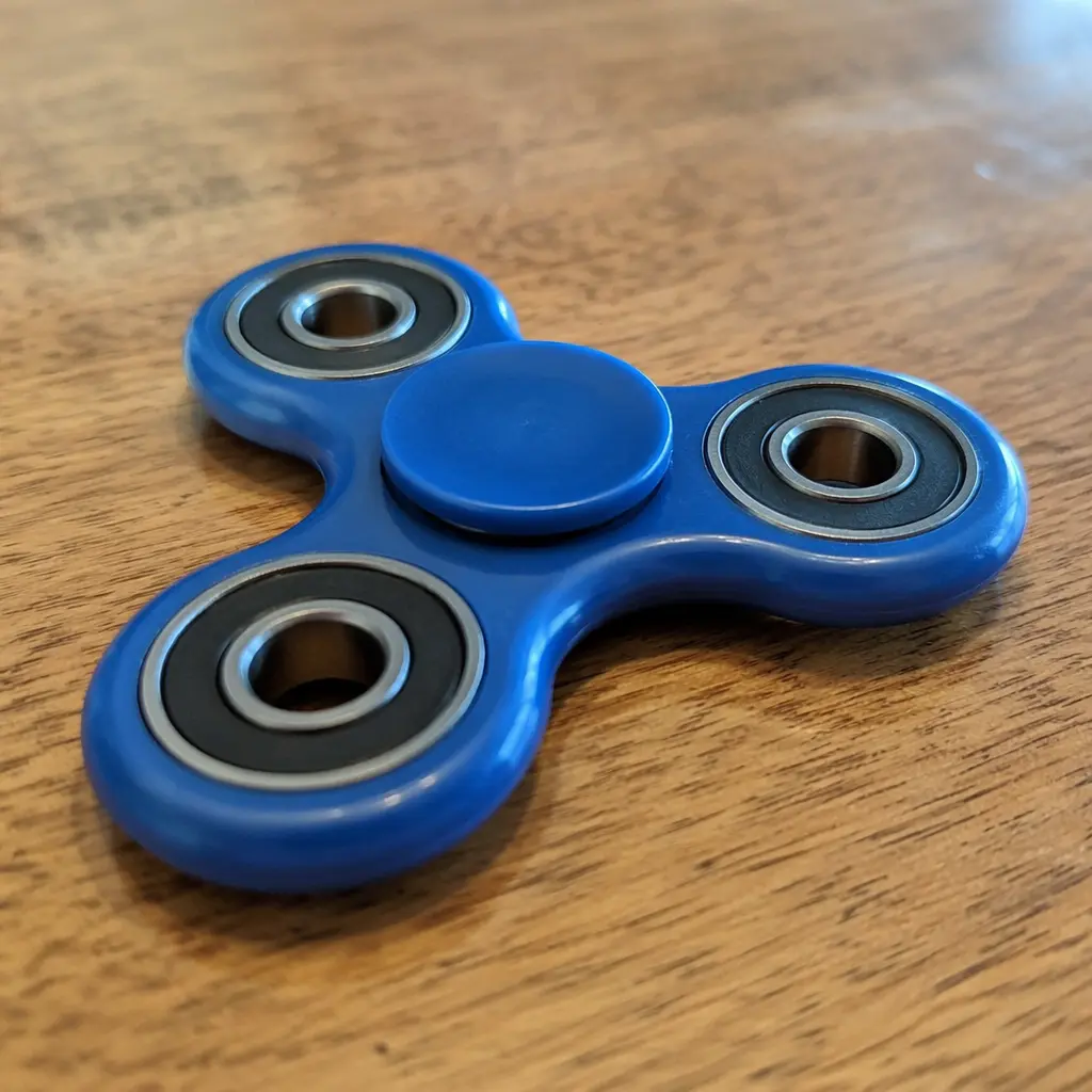 A simple three-lobed fidget spinner on a desk