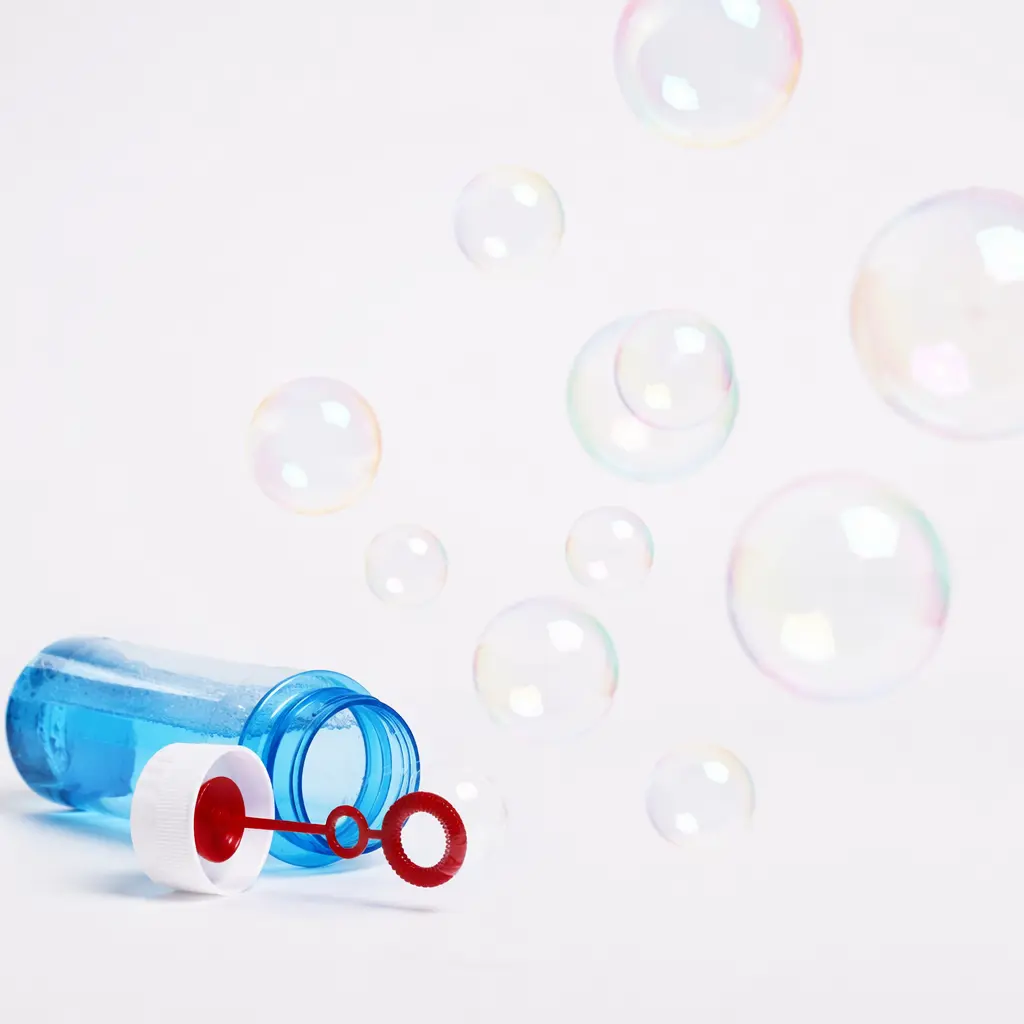 A spill‑resistant bubble bottle with floating bubbles in a clean studio setting
