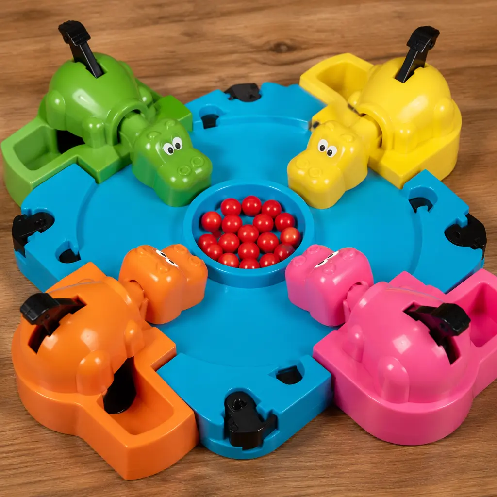 A colorful hippo-themed tabletop game with marbles in the center