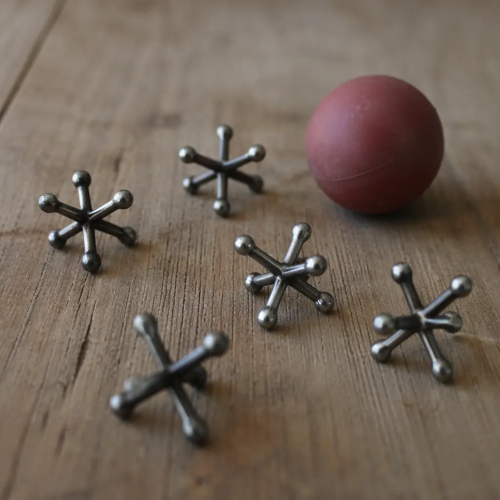 Metal jacks and a small rubber ball arranged on a wooden surface