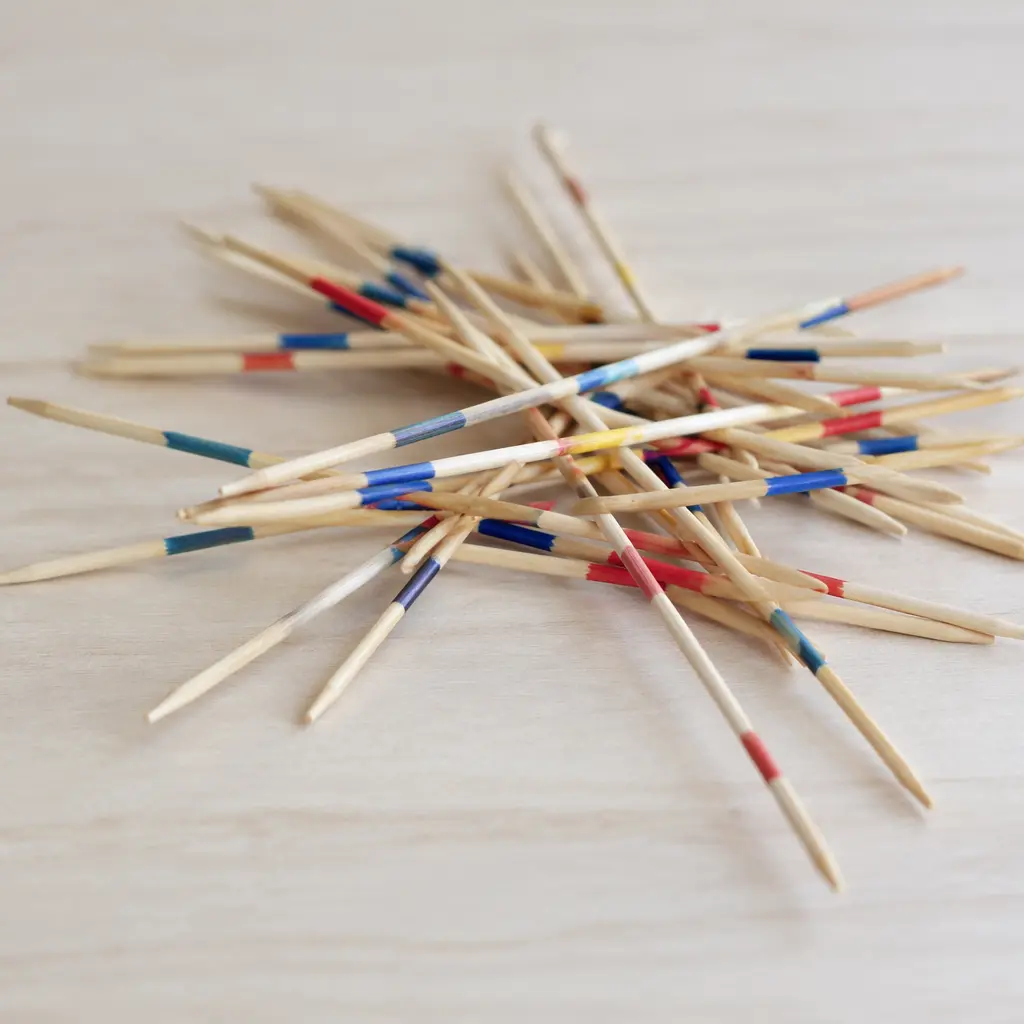 A classic pile of wooden pick-up sticks spread across a table