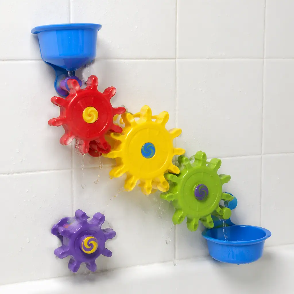 Interlocking bath gears spinning on a tiled wall with water running over them